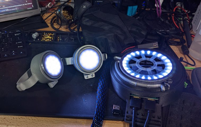 Two repulsors and the arc reactor lit up on the workbench, LED rings glowing